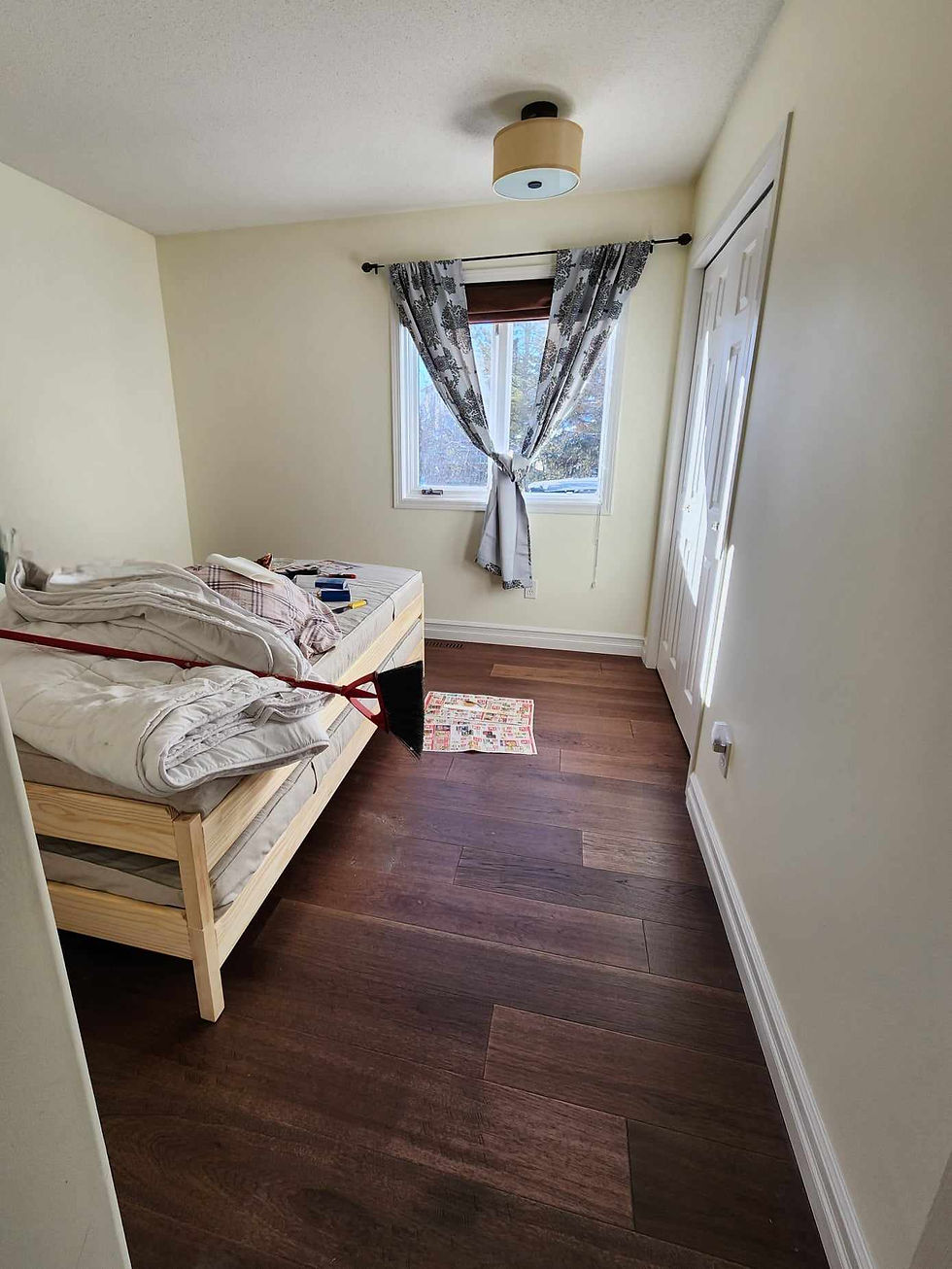 A room with an unmade bed in the middle of it.