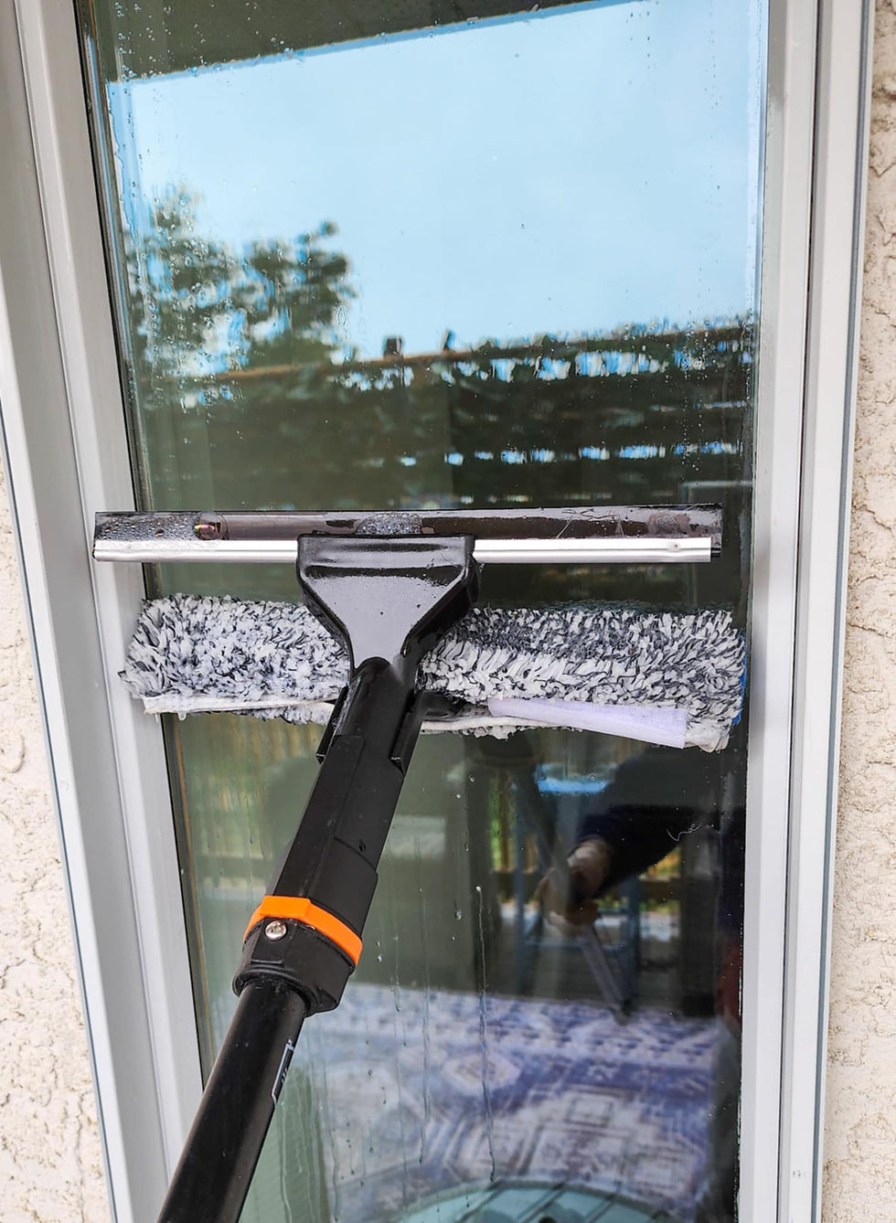 Using a scrubby and squeegee to clean the windows.