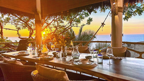 huge live tropical wodd dining table overlooking ocean at sunset for all your guests at Casa NOsara, a luxury rental in Sayuliya