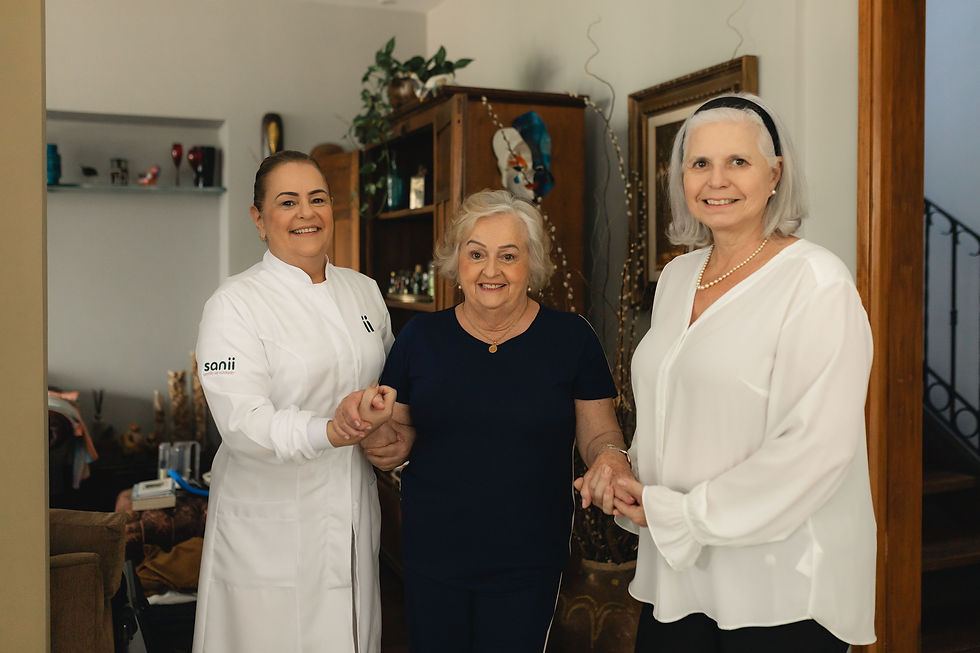 cuidadoras segurando as mãos de uma idosa