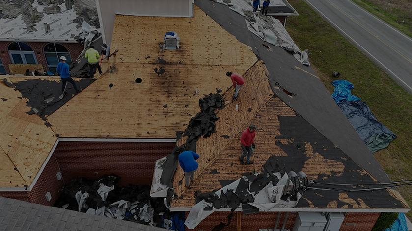 Roofers repairing storm damage on a commercial building, roofing, DeRamus Construction Services.