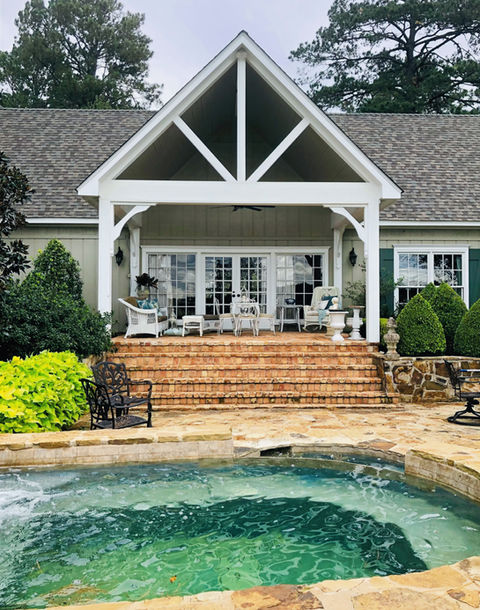 Residential home back porch exterior view with pool. Home is DeRamus Construction Services Natchitoches. 