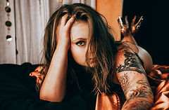 Boudoir Album example presented by woman lying on bed posing in Luminaire Studio in Calgary, Alberta