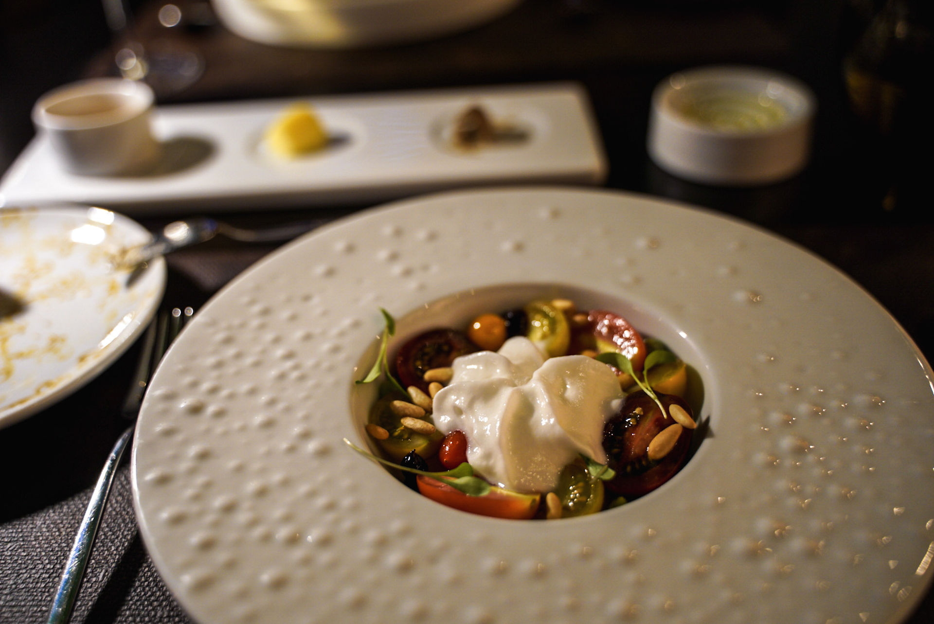 Salade de tomates - tomates cerises, sauce d’avocats, noix de pins et feuilles de laitue 