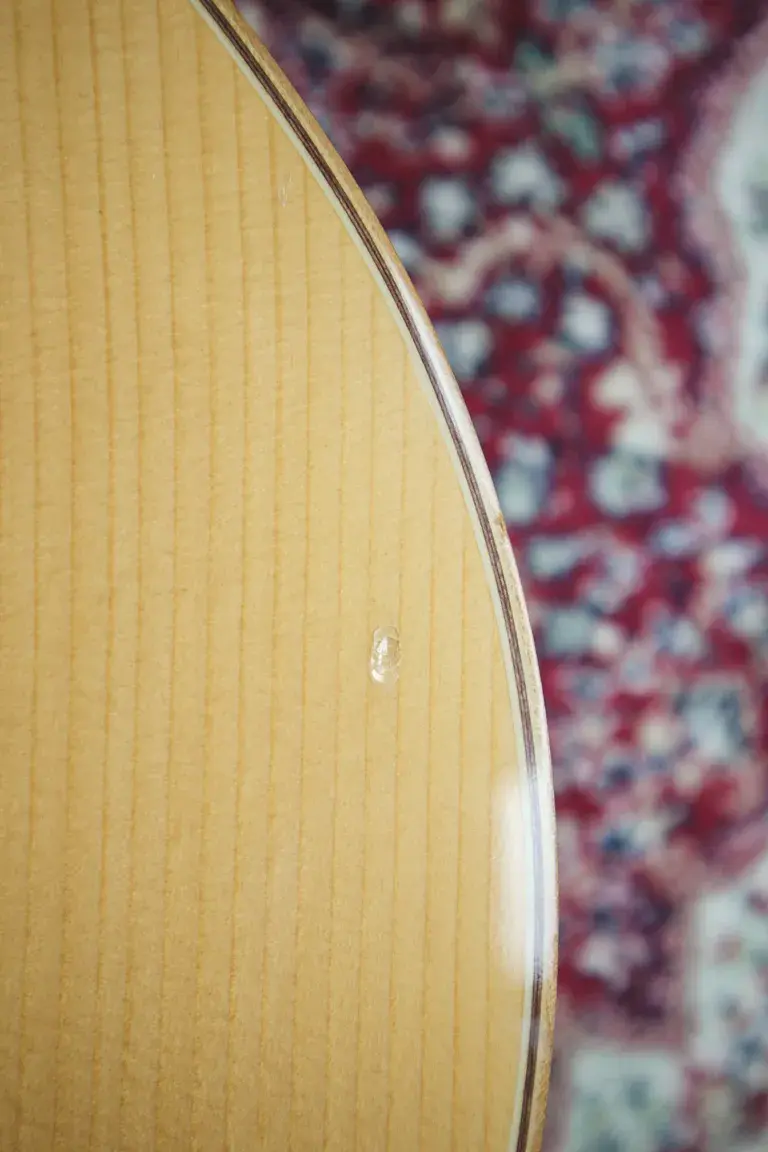 Thumbnail: Close-up of small ding on lower bout of the guitar top.