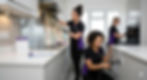 Three professional Spify cleaners, wearing matching black and purple uniforms, are meticulously performing a detailed deep clean in a modern Bridlington kitchen. The team is shown using a grout steamer, cleaning an oven interior, and addressing a kitchen extraction hood to remove deep-seated grime.