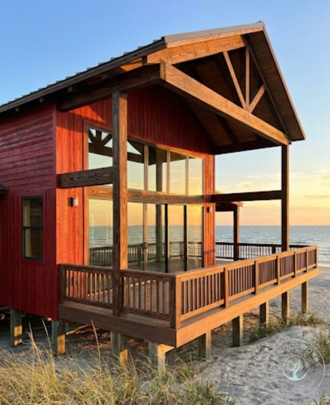 Waterfront cabin on stilts featuring burnt and stained wood siding and a wrap-around shou sugi ban deck.