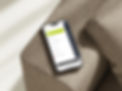 Mockup Smartphone auf Couchlehne mit Tickura Menübersicht im Bild