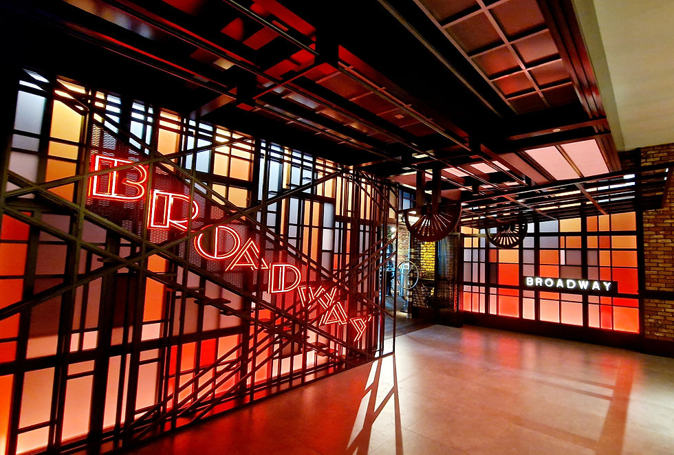 The geometric shapes of the entrance and the predominantly red and orange color scheme of Broadway are striking.
