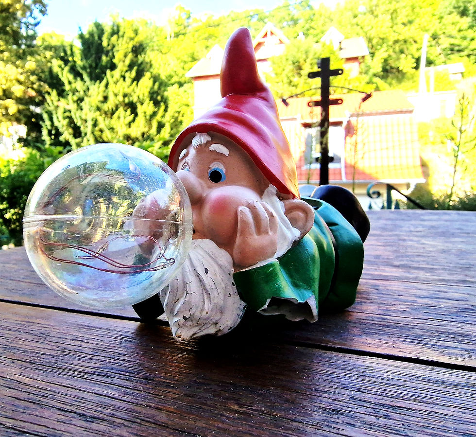 The lying garden gnome with a glass ball in front of its mouth is a lamp.