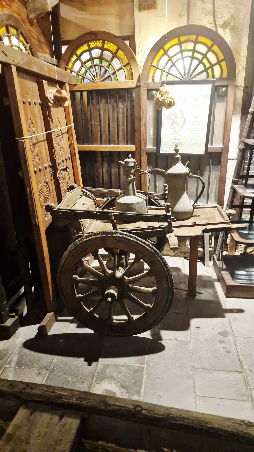 Auf einem alten antiken Holzwagen stehen alte Kaffeekannen.
