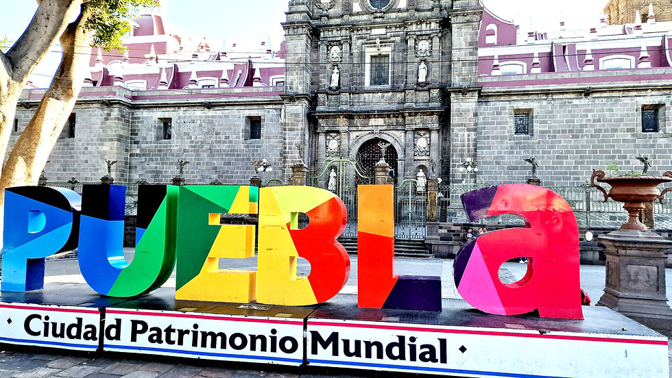 In front of the cathedral, "Puebla" is written in large, colorful letters.