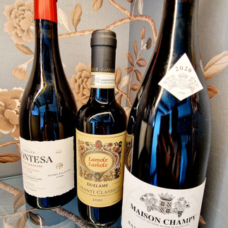 Drei Flaschen Wein und Champagner stehen auf der Anrichte.