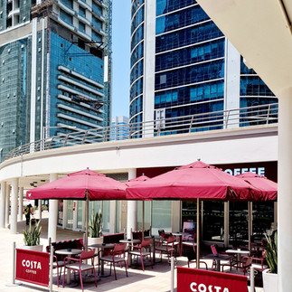 Costa Cafe am Jumeirah Lake Tower. Dahinter ragen Wolkenkratzer in den Himmel. 