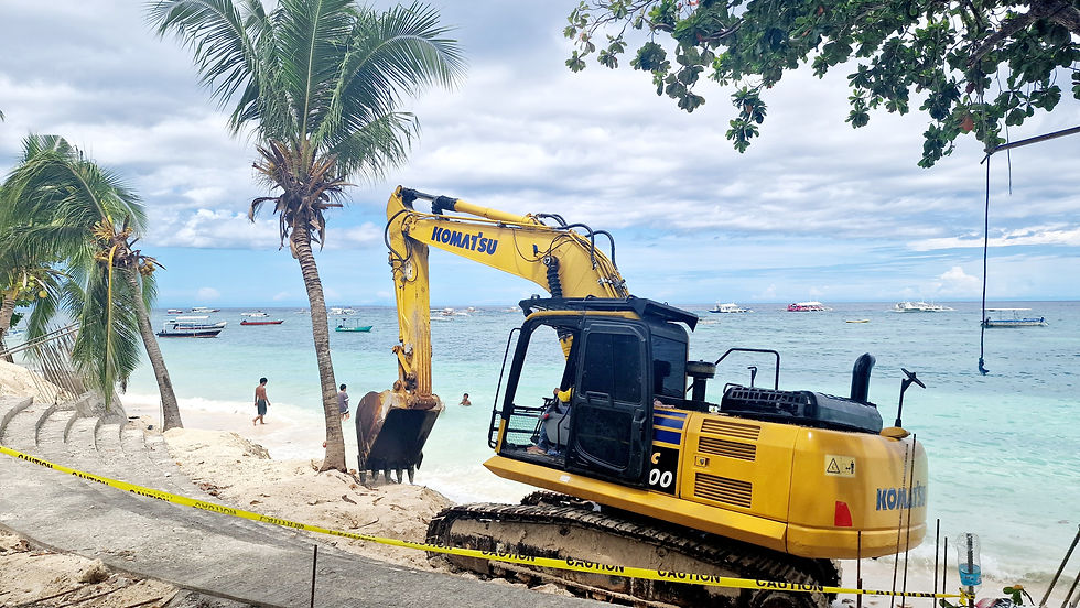 A yellow excavator on the beach suggests that construction work will begin here soon.