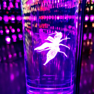 An extraterrestrial insect floats in the violet-lit cylinder.