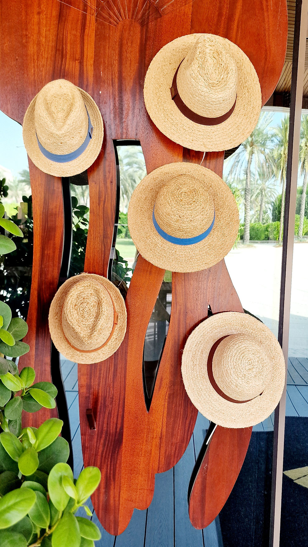 Five straw hats decorate a stall.