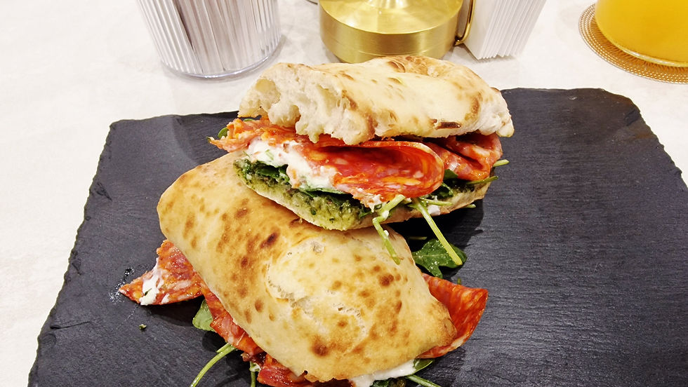 Zwei große Paninis mit scharfer Salami, Salat und Kräutern.