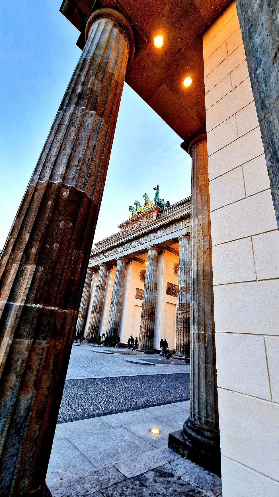 The Brandenburg Gate photographed from the side with blue sky.