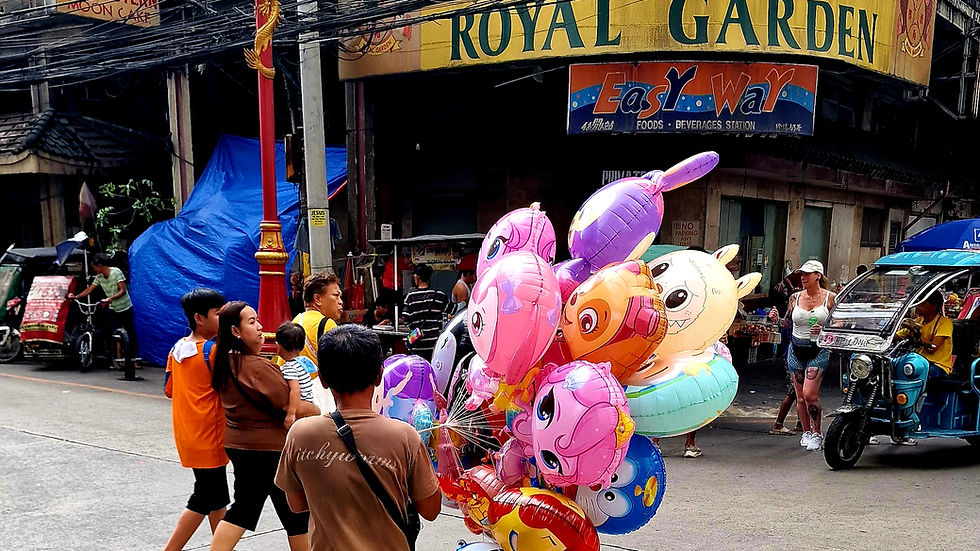 A man walks through Chinatown trying to sell his colorful balloons.