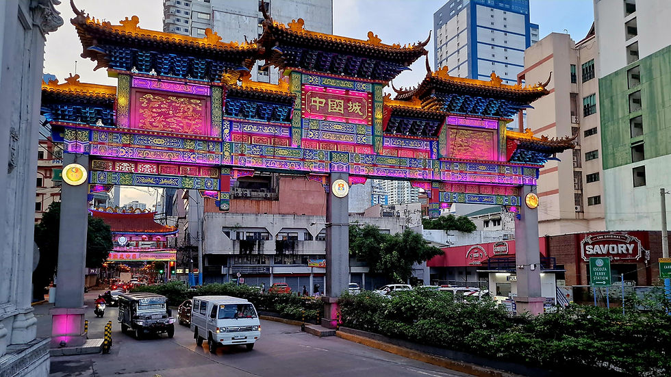 A large Chinese colorfully illuminated gate leads to Chinatown Manila.