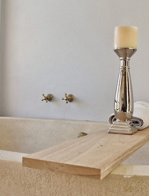 Luxury interior design: bathroom tub, wooden caddy, & candle. Decor by Kachi Interiors London