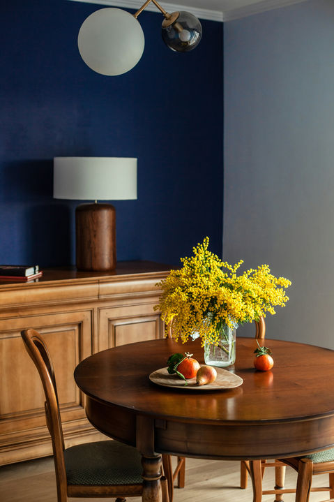 Round wooden dining table with mimosa flowers
