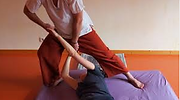 une personne allongée sur un futon et qui est étirée par les bras pour relâcher les tensions