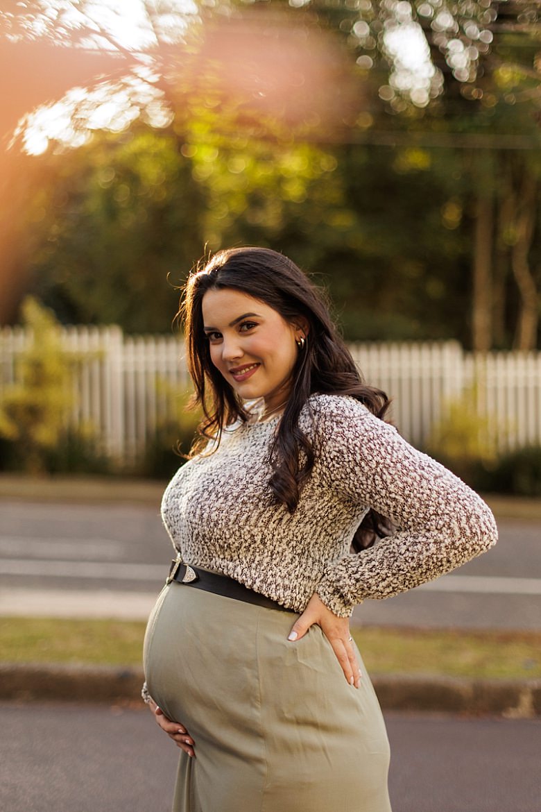 Gestante ao pôr do sol posando para ensaio fotográfico de gestante