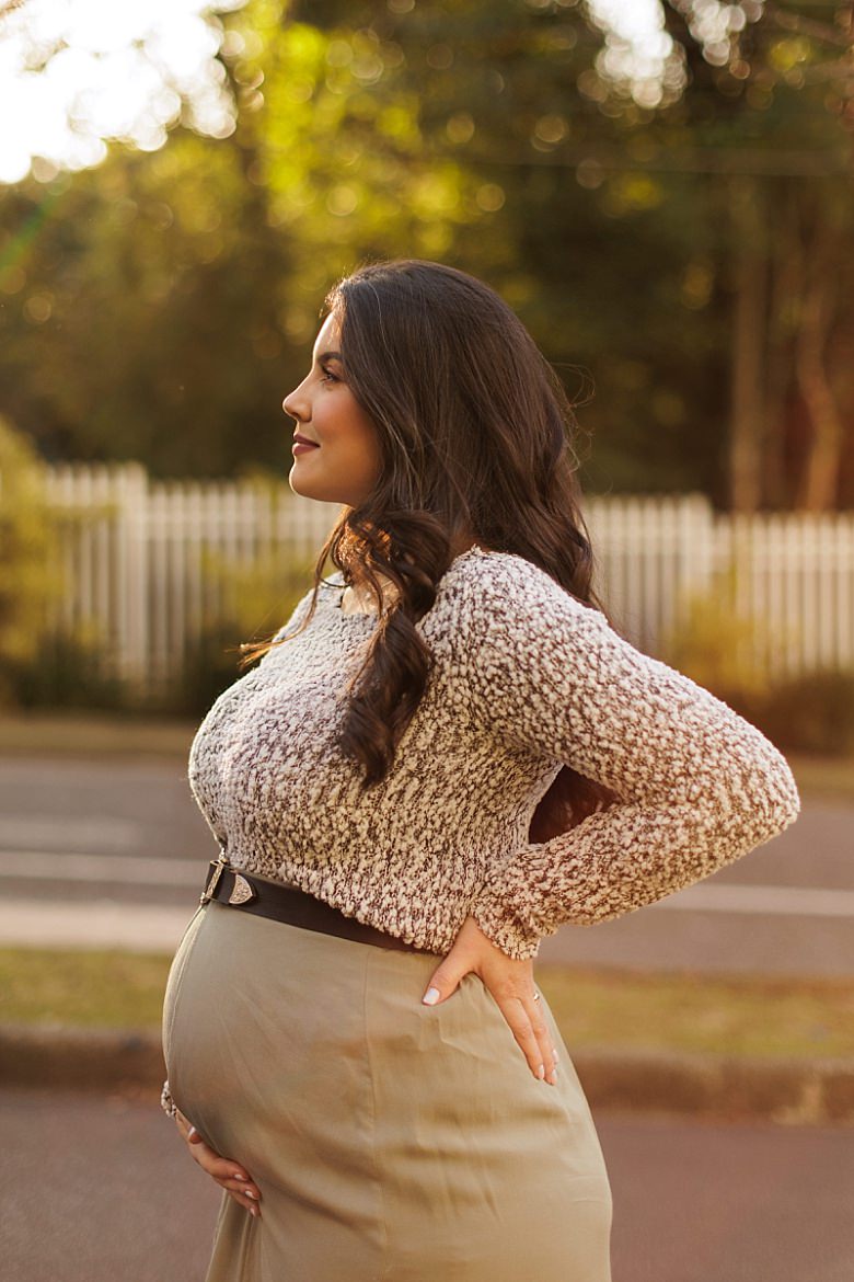 Gestante ao pôr do sol posando para ensaio fotográfico de gestante
