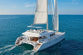Elegant Lagoon 620 catamaran sailing under full sails across the open sea.