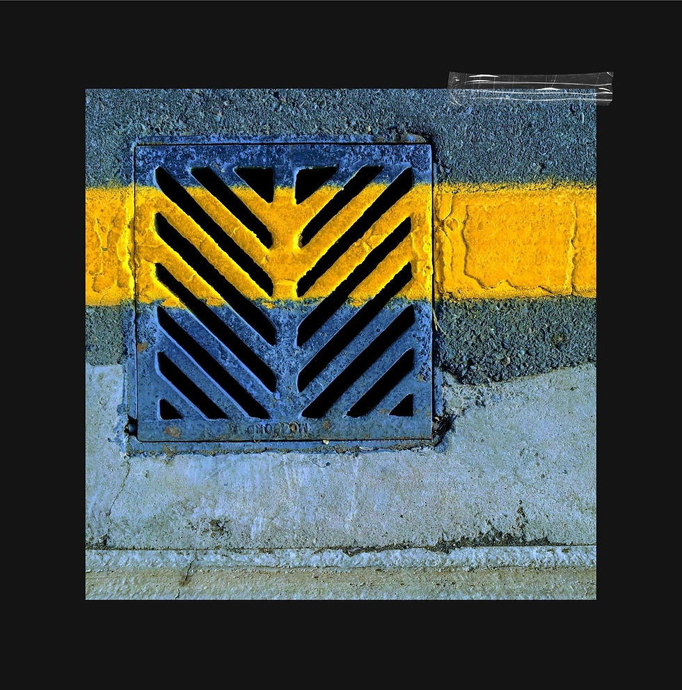 A freshly laid band of yellow road paint cutting across a metal drain grate, the image that inspired STRIPE Urban Minimal Geometric by Genevieve Staats, CreatEVE Design.