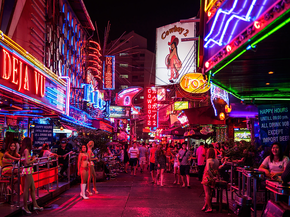 Eye-level view of neon lights illuminating Soi Cowboy streets