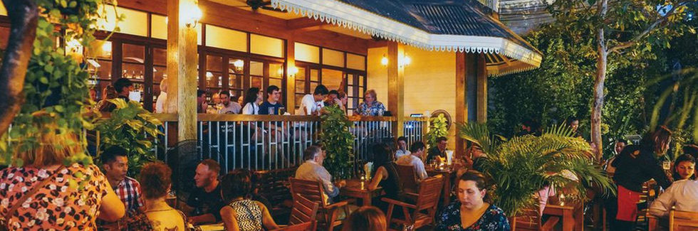 Pub crawl kickoff – travelers at the first bar in Bangkok, enjoying drinks, food, and meeting fellow pub crawlers.