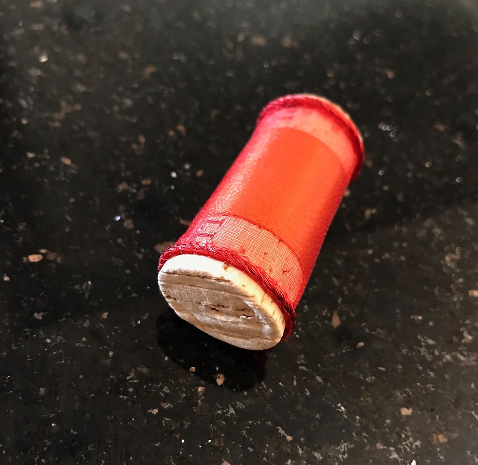 A wine cork wrapped in red ribbon