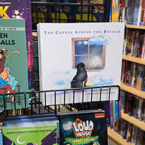 Copies of "The Candle Across the Bridge" on the shelf at a local comic-book shop.