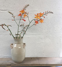Handled stoneware vase, glazed in creamy tin glaze