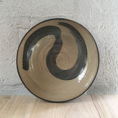Medium sized serving bowl, with swirl of black slip on the inside, and glazed in matt black on the outside. 