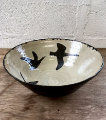 Large  serving bowl, glazed on the outside in matt black, and on the inside with a shino glaze. Geese in flight silhouette in black on the inside of the bowl.