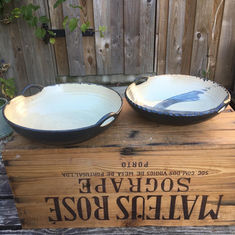 These shallow stoneware serving bowls have dainty handles to complement the elegant and simple form. They are glazed in a tactile matt black glaze, and some have a swirl of black slip on the inside aspect.
