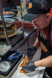 Cook serving fresh pizza at Tasty Pizza Potatoes and More Wright Patterson Air Force Base Exchange Dayton Ohio