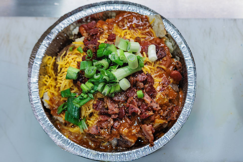 Loaded baked potato with chili cheese and green onions at Tasty Pizza Potatoes and More Wright Patterson AFB Dayton Ohio
