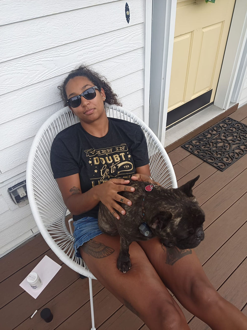 Me, holding a dog on my lap on the porch of a housesit