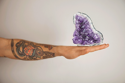 holding amethyst healing crystal