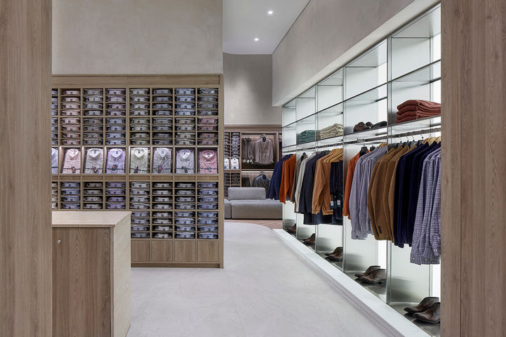 Modern men's clothing store interior with shirts and sweaters on display