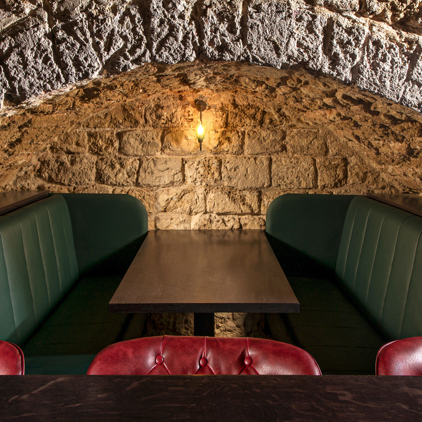 Cozy stone-walled bar alcove with booths