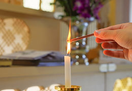 蠟燭火にお線香灯す