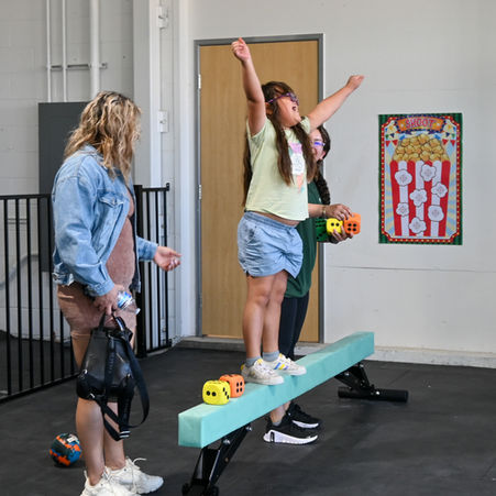 Grand opening attendee of the Kidisthenics El Centro facility using the balance beam.