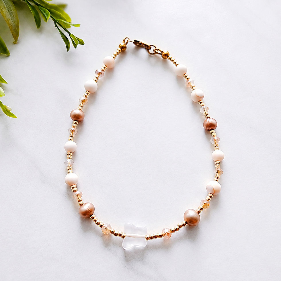 Rose quartz butterfly anklet featuring gold beads champagne pearls and delicate shell bead accents.