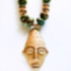 Thumbnail: Handcrafted Obasi statement necklace featuring aqua ceramic beads, African brass beads, and a brass mask pendant.